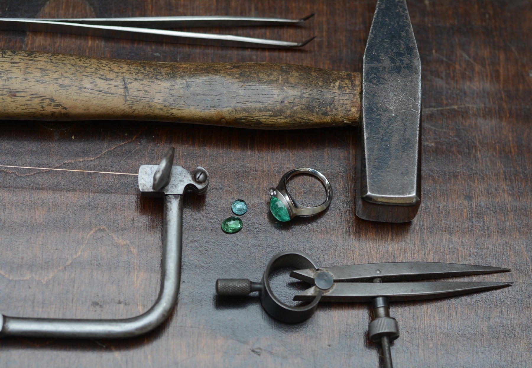 workbench with tools and jewellery - paraiba tourmaline and loose stones