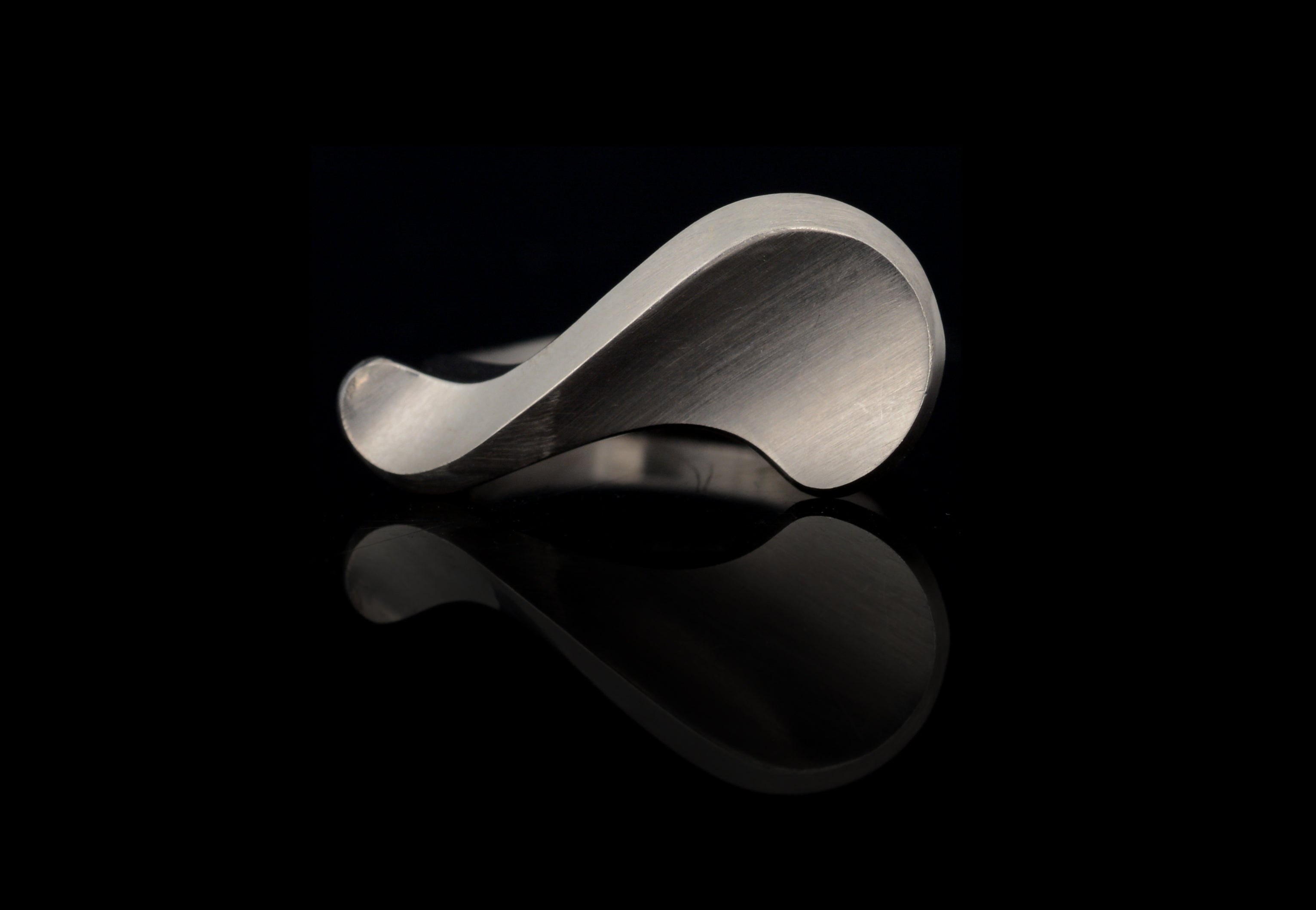 white gold sigma ring on black background